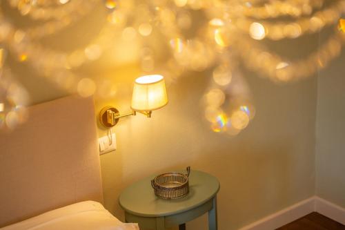 a lamp on a wall next to a bed with a table at La Rocca di Camporgiano in Camporgiano