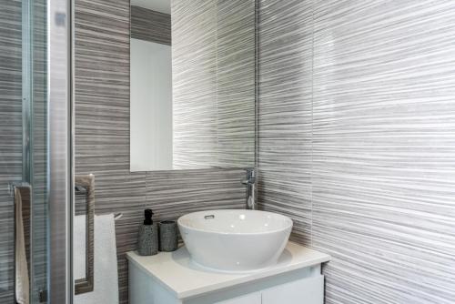 een badkamer met een witte wastafel en een spiegel bij Dusk - Harmonic Studio by Plus 49 in Mackenzie in Larnaka