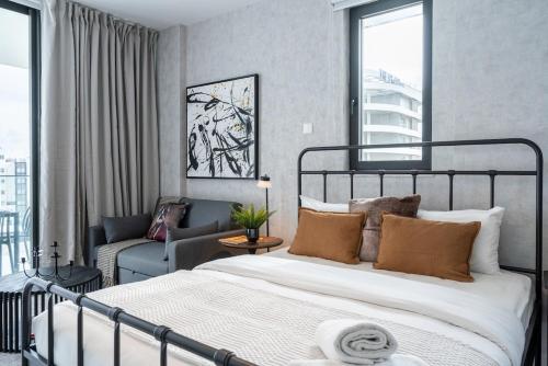 een slaapkamer met een bed en een woonkamer bij Dusk - Harmonic Studio by Plus 49 in Mackenzie in Larnaka