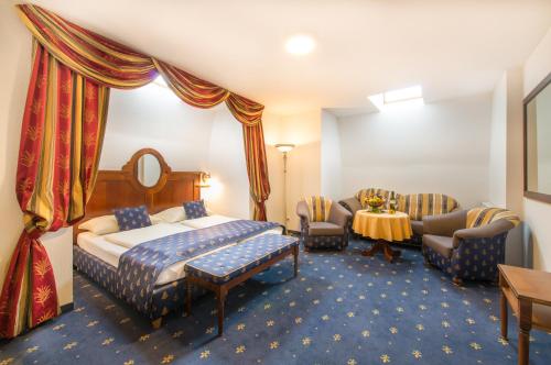 a hotel room with a bed and a table and chairs at Hotel Bayrischer Hof in Wels