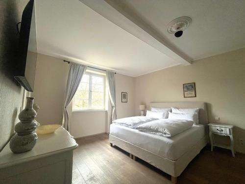 a bedroom with a white bed and a window at KAROLINGERHOF - Mosel in Kröv