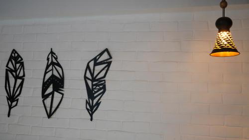 three kites on a white brick wall with a lamp at Julley Commune Rishikesh in Rishīkesh