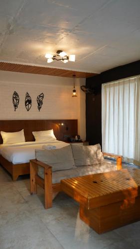 a bedroom with a large bed and a table at Julley Commune Rishikesh in Rishīkesh