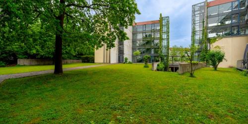 a grassy yard next to a building at PLAZA Residence Stuttgart-Ditzingen in Ditzingen