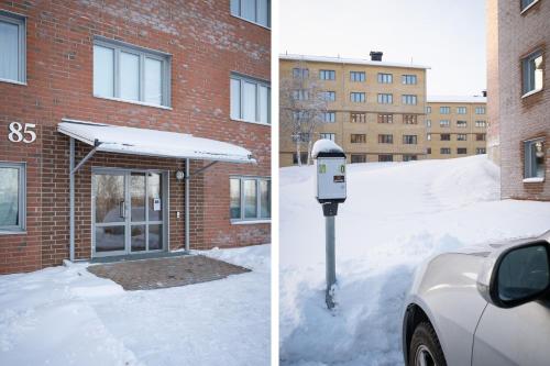a parking meter covered in snow next to a building at Guestly Homes - Nordic Studio in Luleå