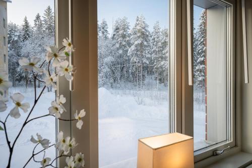 a window with a view of snow covered trees at Guestly Homes - Nordic Studio in Luleå