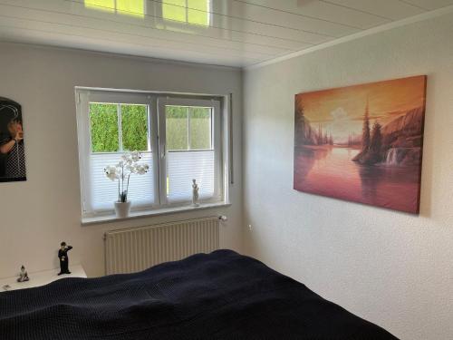 a bedroom with a bed and a painting on the wall at Ferienwohnung Sauer in Tiefenbach