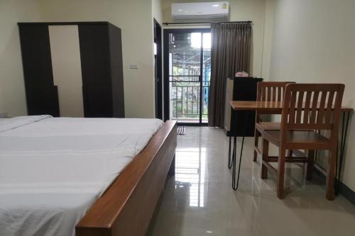 a bedroom with a bed and a desk and a chair at C Park in Ban Bang Nam Chut