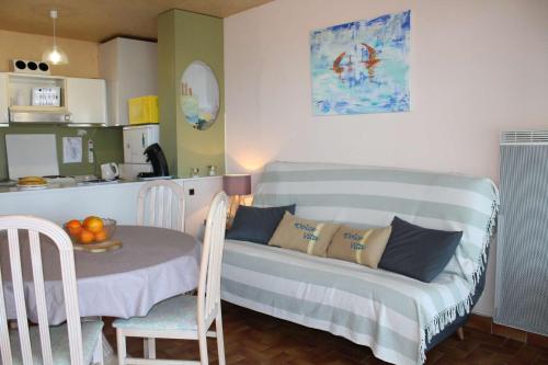 Cette chambre dispose d'un canapé, d'une table et d'une cuisine. dans l'établissement Appartement 2 pièces PORT LA NOUVELLE PN210-010, à Port-la-Nouvelle