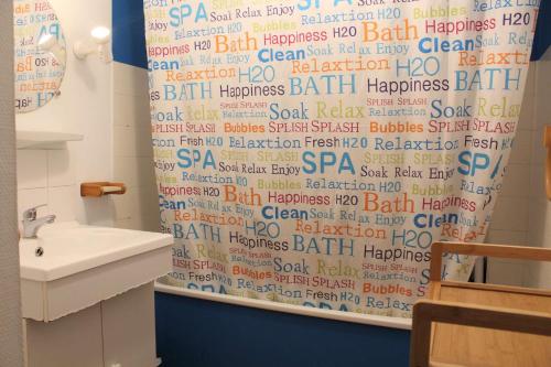 La salle de bains est pourvue d'un rideau de douche avec un écriteau. dans l'établissement Appartement 2 pièces PORT LA NOUVELLE PN210-010, à Port-la-Nouvelle