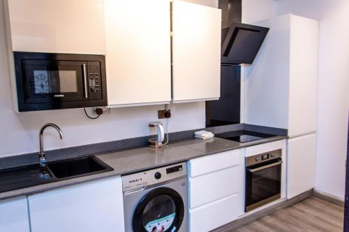 a kitchen with a washing machine and a microwave at George Residence Lekki in Lekki