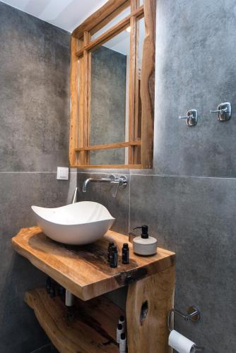 a bathroom with a white bowl sink on a wooden counter at Nikas Guest House in Kanálion