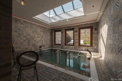 a swimming pool in a house with a skylight at Vera HOTEL-VILLA in Pristina
