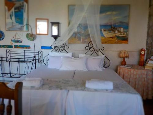 a bedroom with a large white bed with white pillows at Traditional house in Sigri in Sígrion