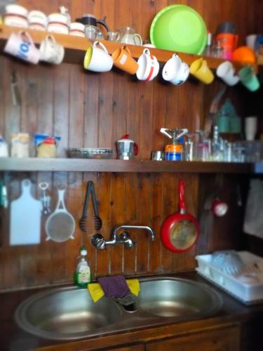 a kitchen sink with pots and pans on the wall at Traditional house in Sigri in Sígrion