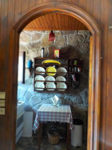 a kitchen with a table and a shelf with plates at Traditional house in Sigri in Sígrion