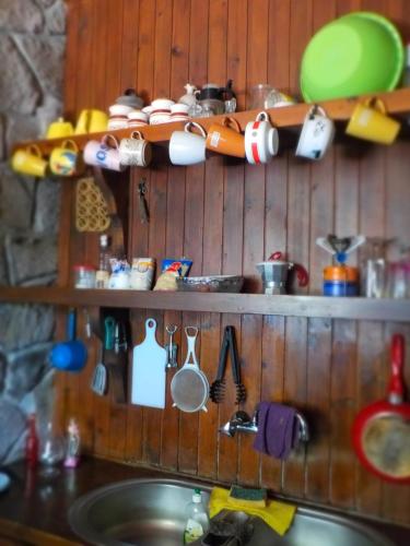 a shelf above a kitchen sink with pots and pans at Traditional house in Sigri in Sígrion
