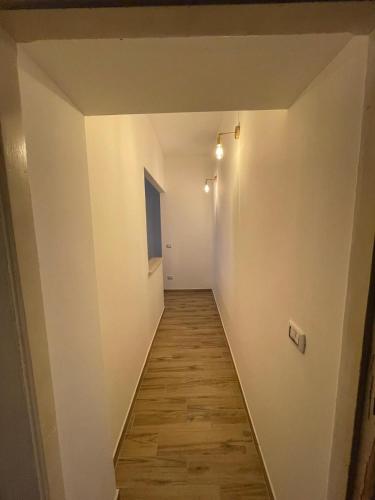 a hallway with white walls and a wooden floor at APPARTAMENTO JLENIA in Cisterna di Latina