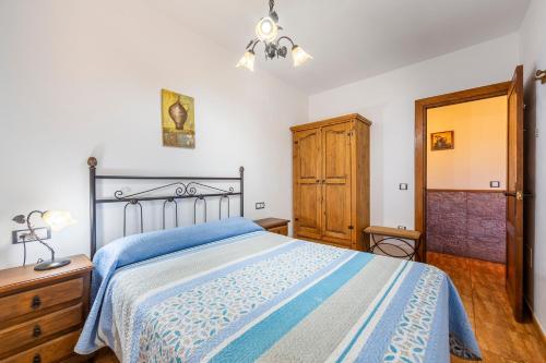 a bedroom with a bed with a blue bedspread at Casa Rural La Jirola -Vivienda 2 in Escúllar