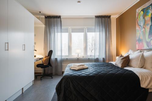 a bedroom with a bed and a desk and a window at Guestly Homes - Cozy Studio in Luleå