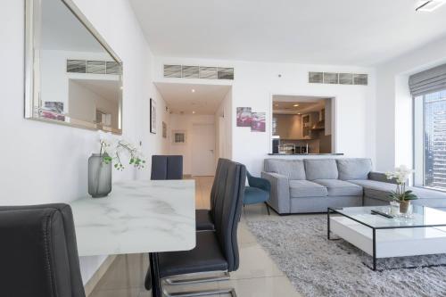 a living room with a table and a couch at Signature 2BR with Burj Khalifa & Fountain View in Dubai