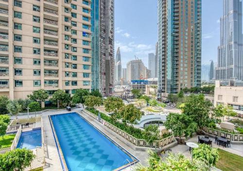 an overhead view of a pool in a city with tall buildings at Signature 2BR with Burj Khalifa & Fountain View in Dubai
