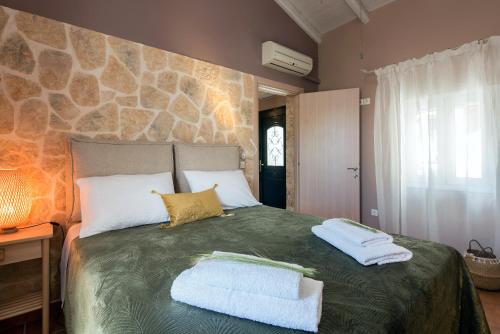 a bedroom with a large bed with two towels on it at Nikas Guest House in Kanálion