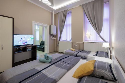 a room with two beds and a flat screen tv at Apartments Borovo in Subotica