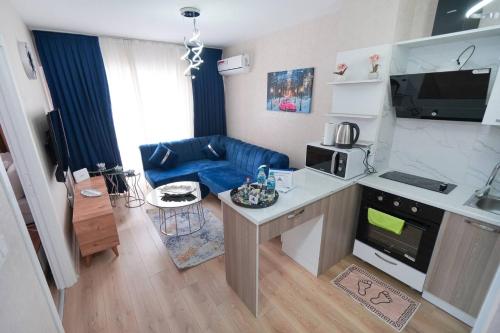eine kleine Küche und ein Wohnzimmer mit einem blauen Sofa in der Unterkunft Classic Suite TS33 in Esenyurt