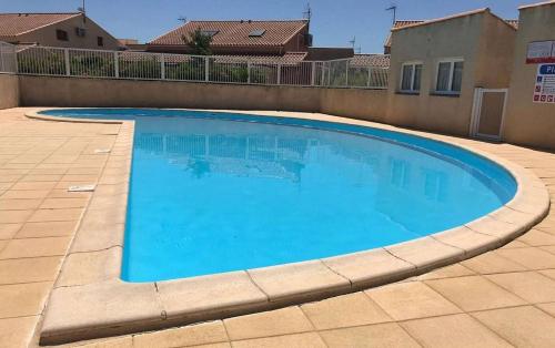 une grande piscine bleue dans une cour dans l'établissement Maison 2 pièces mezzanine - Gruissan Ayguades AY060-135, à Vires