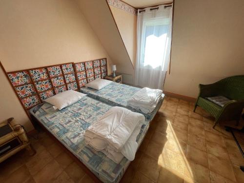 une petite chambre avec un lit et une fenêtre dans l'établissement Loctudy T2 vintage terrasse vue mer, à Loctudy