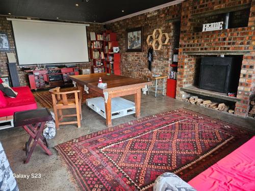 a living room with a table and a brick wall at Stoepsit in Yzerfontein