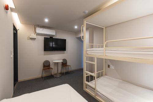 a room with bunk beds and a flat screen tv at Mumune Stay in Seoul