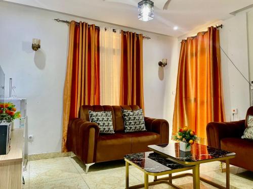 a living room with a couch and orange curtains at Gombe243 in Kinshasa