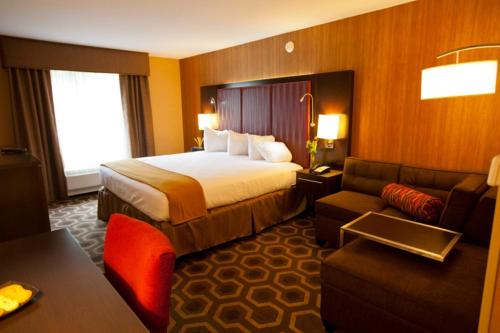 a hotel room with a bed and a couch at Holiday Inn Express Hotel & Suites Vineland Millville by IHG in Vineland