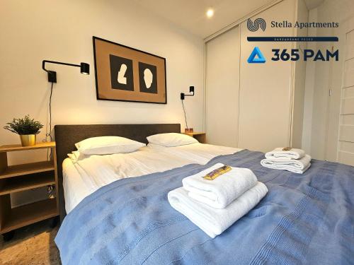 a bedroom with a bed with towels on it at 365PAM - Apartament Bliżej Morza w Gąskach in Gąski