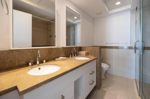a bathroom with two sinks and a shower at Signature 2BR with Burj Khalifa & Fountain View in Dubai