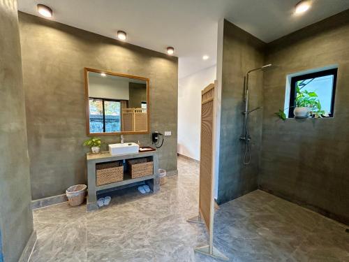 a bathroom with a shower and a sink at Enchanted Pool Bungalows Siem Reap, right near the Wake Park in Phumĭ Kruŏs