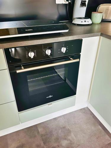 un four noir dans une cuisine avec un comptoir dans l'établissement BO'M Appart, à Tourcoing