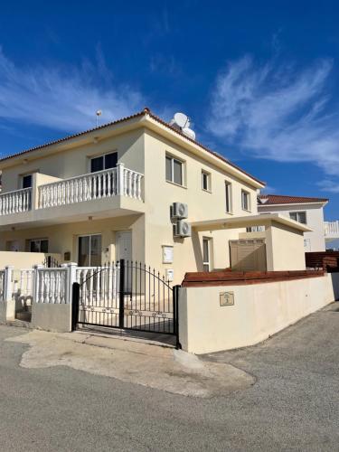 a white house with a black fence in front of it at Nissi Villa in Ayia Napa
