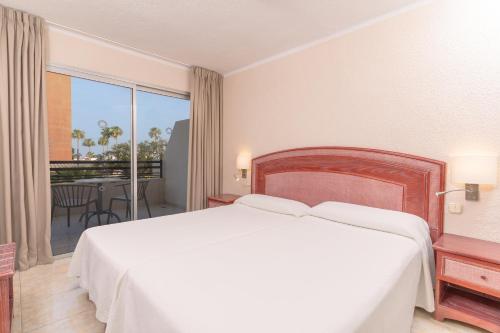 a bedroom with a large white bed and a balcony at HOVIMA Santa María in Adeje