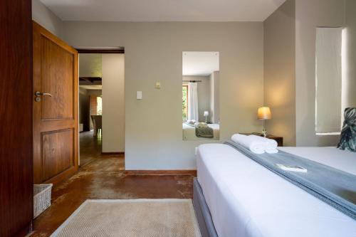 a bedroom with a large bed and a mirror at Raptors Wildlife Escapes in Hoedspruit