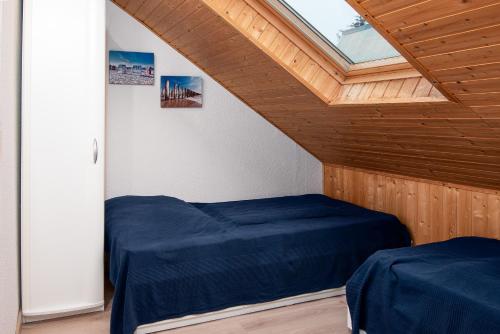 ein Schlafzimmer mit zwei Betten und einem Fenster in der Unterkunft Huus Gerda in Krummhörn