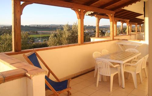 a porch with a table and chairs on a balcony at 2 Bedroom Stunning Apartment In Isola Capo Rizzuto in Isola Capo Rizzuto