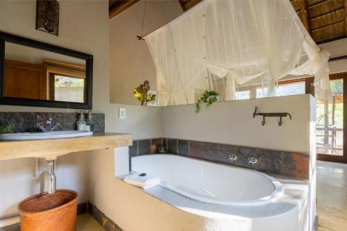a large bathroom with a tub and a sink at Raptors Lodge in Hoedspruit