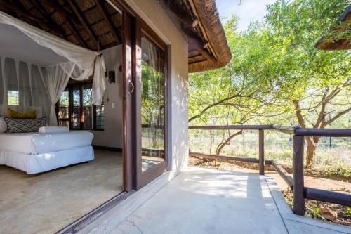 a room with a balcony with a couch on a porch at Raptors Lodge in Hoedspruit