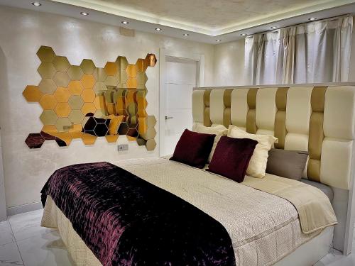 a bedroom with a large bed and a painting on the wall at CENTRO, PARKING, PISCINA 2 Dormitorios SUITE PONDOS in Linares