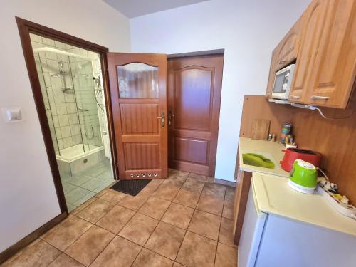 a kitchen with a sink and a door to a bathroom at Kacperek w centrum Willowa 4A in Szczyrk