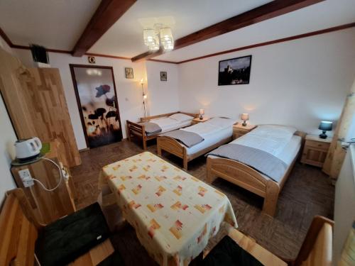 a hotel room with two beds and a table at Arenda Noclegi Niedzica in Niedzica
