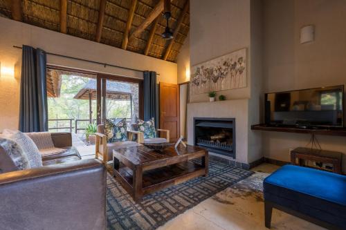 a living room with a couch and a fireplace at Raptors Lodge in Hoedspruit
